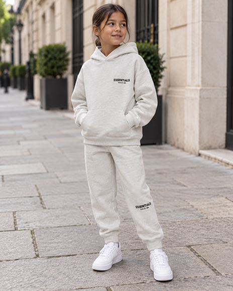 Kind trägt Essentials Hoodie und Jogginghose in Light Oatmeal – SneakerMood